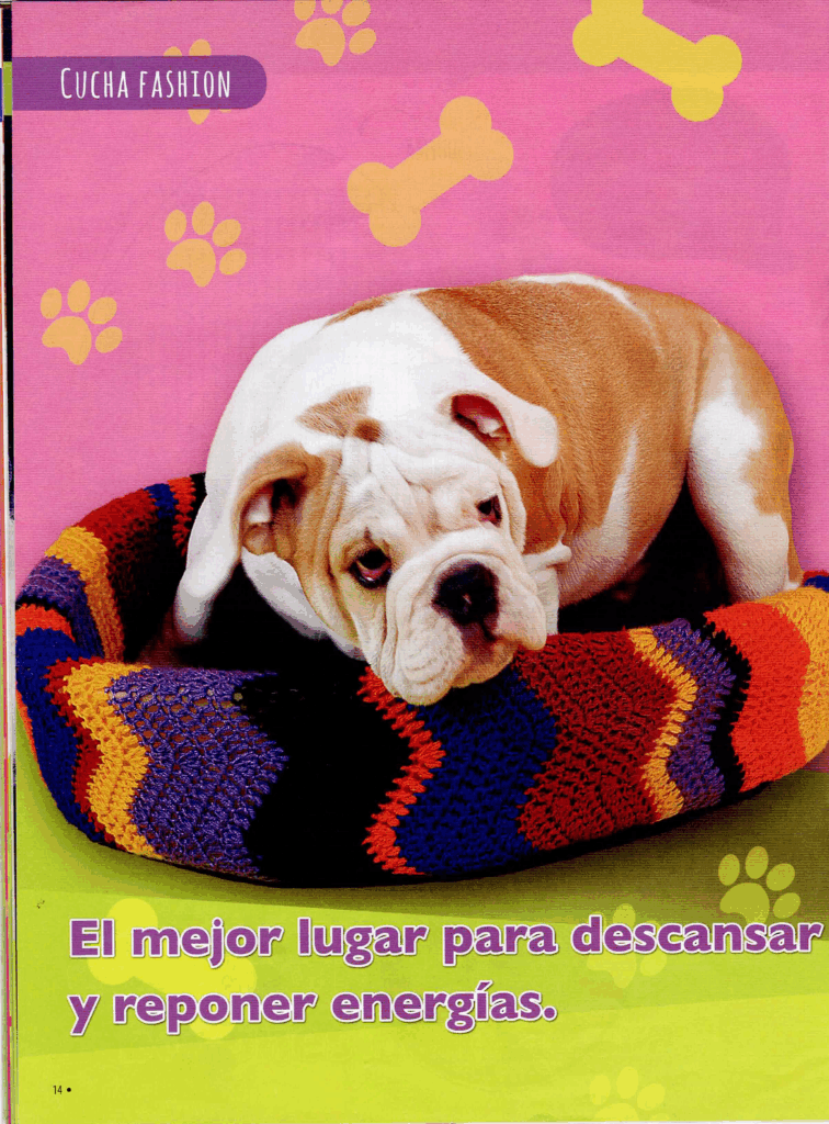 Cachorro bulldog marrón y blanco recostado en una cama multicolor de crochet con fondo rosado decorado con huellas y huesos amarillos. Texto en la parte inferior que dice: "El mejor lugar para descansar y reponer energías."