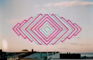 Fotografía análoga de techos en la ciudad de Punta Arenas, intervenida con bordado con figuras geometricas cuadradas.