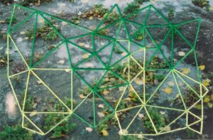 Fotografía de agua congelada sobre pasto verde y hojas de arbol, intervenida con bordado en formas geometricas triangulares irregulares, en colores verdes..